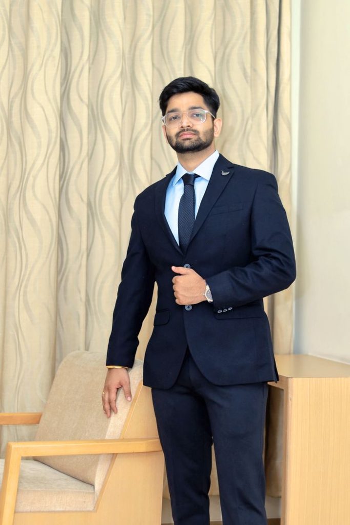 Adult man in formal attire posing indoors; professional fashion photoshoot.